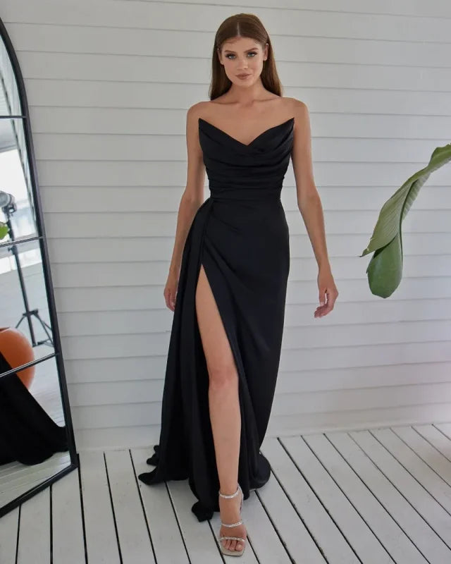 Vestido formal rojo sin tirantes con hombros descubiertos y diseño de sirena plisado.